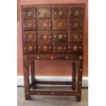 An Indonesian Hardwood Apothecary Style Chest Of Drawers, with four rows of four drawers,