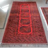 A Kashmir Machine Made Rug, Decorated with five geometric panels on a red ground, 208 x 108cm