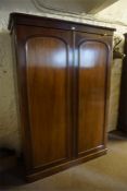 A Victorian Mahogany Wardrobe, with moulded cornice above two panelled doors enclosing fitted