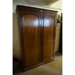 A Victorian Mahogany Wardrobe, with moulded cornice above two panelled doors enclosing fitted