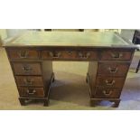 A Reproduction Mahogany Kneehole Desk, with a tooled green leather skiver above a large drawer