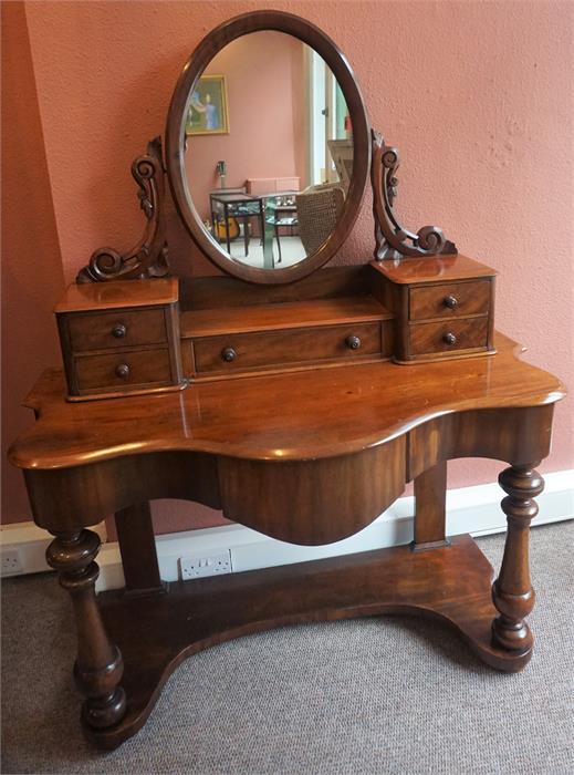 A Victorian Mahogany Dressing Table, with swing mirror above fitted drawers and large drawer, with