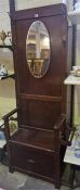 An Oak Hallstand, with a mirror above a hinged seat, flanked with a stick stand compartment with