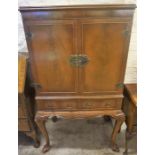 A Walnut Cocktail Cabinet, with two doors enclosing a fitted interior, above two drawers, 135cm