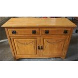 A Vintage Light Oak Sideboard, with two small drawers above two panelled doors, having Arts & Crafts