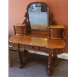 A Victorian Mahogany Dressing Table, with a swing mirror flanked by three small drawers, above a
