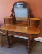 A Victorian Mahogany Dressing Table, with a swing mirror flanked by three small drawers, above a