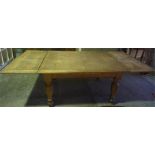 An Oak Pull Out Dining Table, circa 1930s, raised on turned legs, 75cm high, 235cm long, 107cm wide