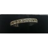 An Eternity Ring, with multiple small stones on a white metal shank,