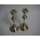 A Pair Of Silver Candlesticks, with turned stem, raised on circular foot, 18cm high, overall