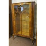 A Vintage Walnut China Cabinet, with a glazed door enclosing glass shelves, raised on cabriole feet,