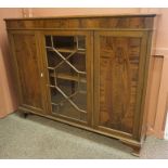 A Mahogany Display Cabinet, with a glazed astragal door, flanked with a panelled door, enclosing