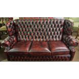 A Chesterfield Ox Blood Hide Three Seater Sofa, Having a high wing back, 91cm high, 191cm wide