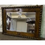 An Oak Framed Wall Mirror, circa 1940s, Decorated with spiral columns and a roundel to top and