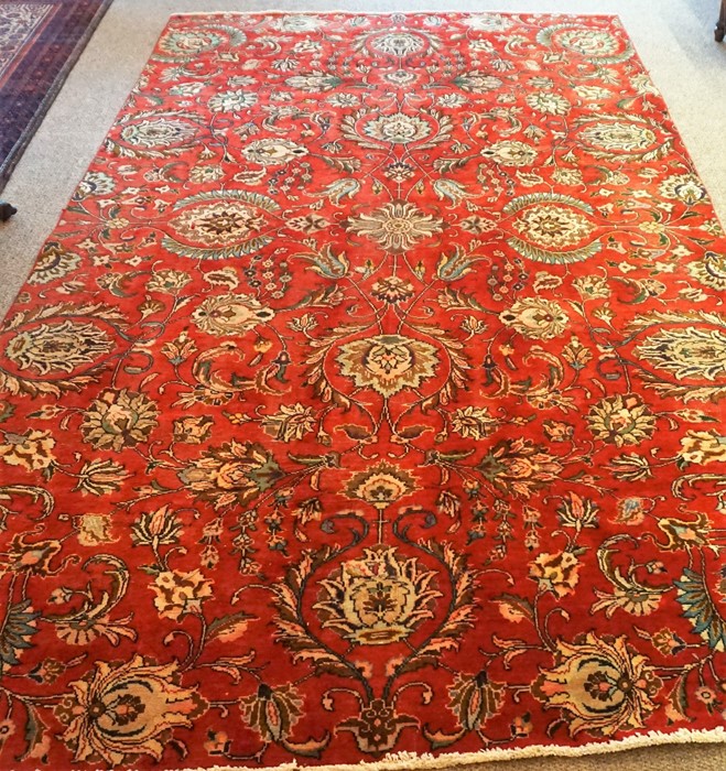 A Large Tabriz Rug, Decorated with all over floral medallions on a red ground, 320 x 185cm