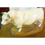 A Beswick Figure of a Bull, Raised on a wood effect plinth, 15cm high