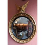 A Regency Style Convex Wall Mirror, With a gilded eagle surmount to the top, decorated with ball