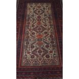 A Persian Bluch Rug, Decorated with fourteen rows of five geometric symbols on a cream and red