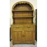 An Oak Dresser, with open shelving above two drawers and two panelled doors, enclosing a shelved