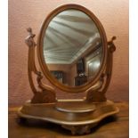 A Victorian Mahogany Dressing Mirror, with an oval swing mirror, raised on a shaped table base, 67cm