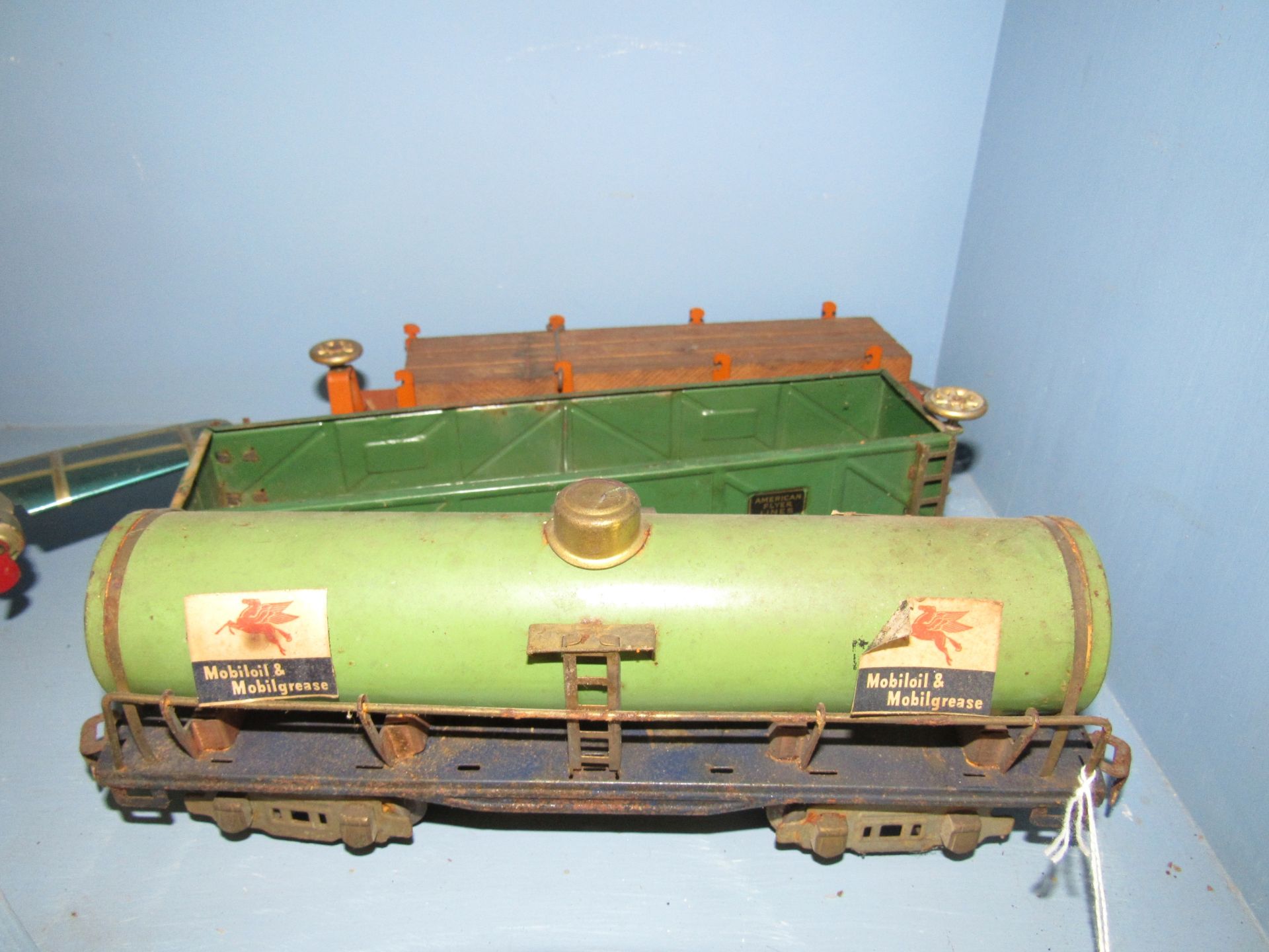 Three cars from a train set, Mobil Gas, log truck, and American Flyer Lines