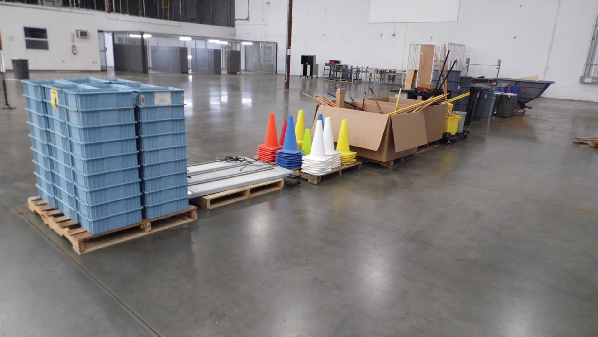 ROW OF PLASTIC TOTES, LIGHTS, BROOMS, AND TRASH CANS