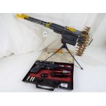 A tin-plate battery operated machine gun on tripod stand by Mo Dean Toys, with ammunition magazines,