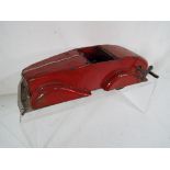 An early tinplate red toy motor car bearing no identification marks,