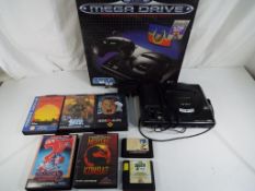 Sega - A boxed Sega Mega Drive console with six game cartridges including Altered Beast,