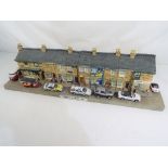 A scale model depicting Coronation Street to include a number of scale model motor vehicles and