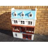 A dolls house in the style of a detached dressmakers shop with living accommodation above and below