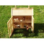 A wooden doll house by Chad Valley, partly furnished with three residents, 60cm x 52cm x 23cm,