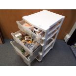 Dolls House furniture - a four drawer storage cabinet containing a quantity of good quality dolls