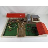 A wooden farmyard playset with a quantity of metal farm animals, pigs, cows, horses,