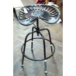 A cast iron adjustable tractor seat stool in black