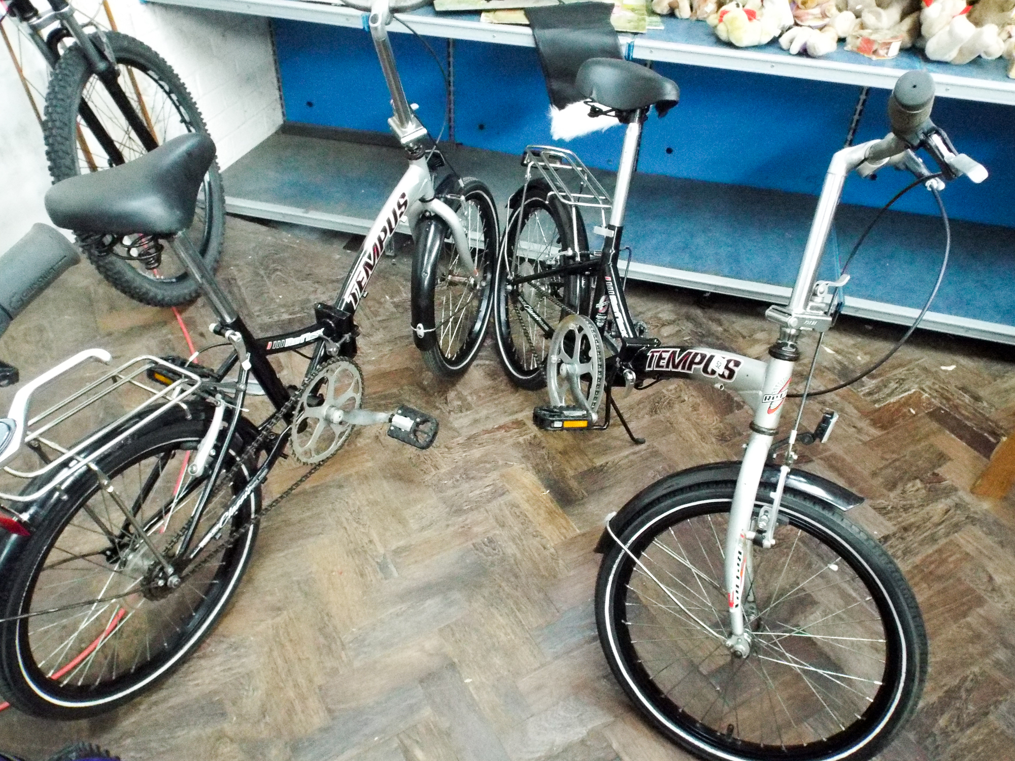 A pair of matching Tenpus Silver and black folding bicycles