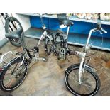 A pair of matching Tenpus Silver and black folding bicycles