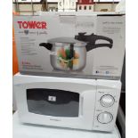 A Daewoo microwave oven in a white case and a six litre stainless steel pressure cooker