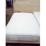 A 4' divan with spring interior mattress and beige headboard