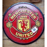 A circular cast iron 'Man United' plaque