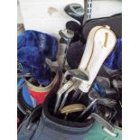 Four golf bags with various golf clubs