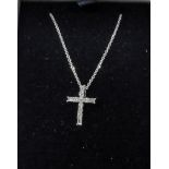 Modern baguette and brilliant cut diamond cross pendant on a fine gold chain