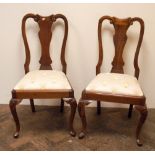 A set of eight Queen Anne style mahogany dining room chairs standing on cabriole legs with cream