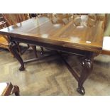 A 1920's mahogany drawer leaf dining table standing on cabriole style legs