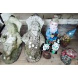 Two large reconstituted stone people sitting on a chair and approx six plastic pixies and other