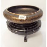 A Japanese cloisonne bowl with a black ground with card hardwood stand,