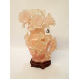 A pink rose quartz vase and cover heavily carved and decorated with peonies overall height 27cms