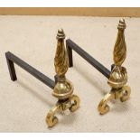 A pair of brass and iron fire dogs