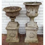 Two reconstituted stone urn shaped garden planters on square pillar base