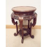 A Chinese carved hardwood two tier bust or plant stand with carved shaped legs and fret frieze